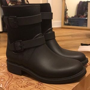Black rubber rain boots with buckles.